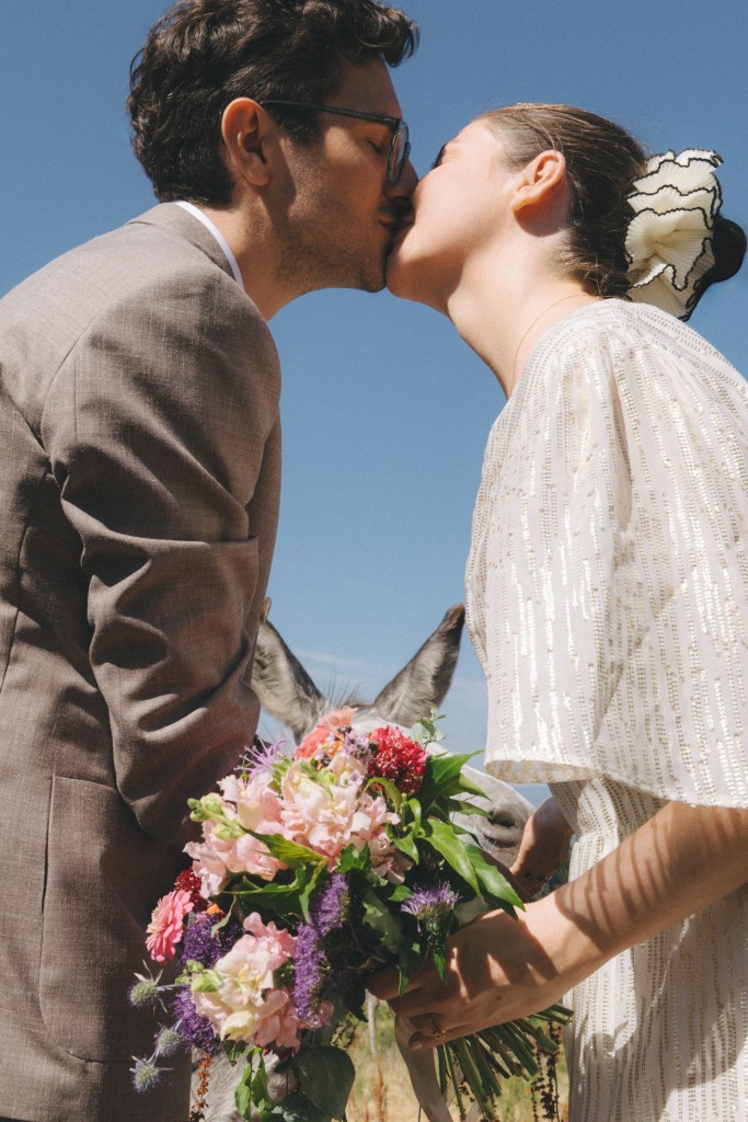 couple amoureux avec un arrière plan amusant d'un animal caché derrière un bouquet de fleur 